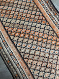 Featherweight flat weave runner with playful tangerine highlights.
