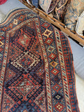 Antique Caucasian rug with bold geometric field and alternating tribal borders.