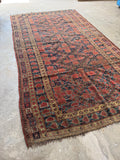 Antique Persian rug in unique size featuring traditional tribal field and geometric borders.