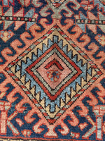Close up of 1920s Persian Gharajeh scatter rug, stout and solid with low pile, geometric motifs, and traditional ram’s horn symbols.