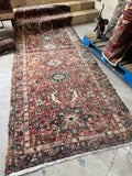 Mid century Persian Gharajeh runner rug with stacked geometric medallions and tribal village artistry.
