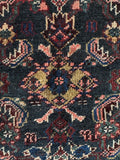 Close up of antique Malayer rug detail showing geometric fish motifs and vegetable dyed wool.