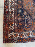 Corner view of vintage Persian Shiraz rug showing natural age, repairs, and rich vegetable dyes.