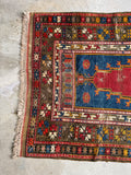 Antique Turkish prayer rug showing traditional geometric borders and star symbols.