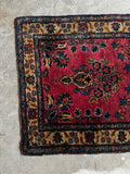 Vintage floral Persian rug with a distinct yellow floral border framing a vibrant berry red center.
