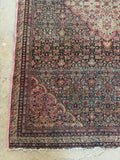 Corner view of botanical pattern with small-scale motifs in antique Persian rug.