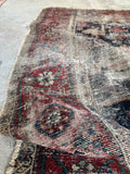 Antique Malayer rug detail showing dark red border band with decorative pattern.