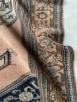 Border band close up from a Persian rug from the 1920s with graphic design and soft tones.