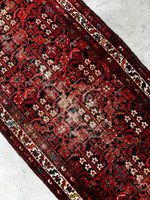 Graphic repeating pattern along a long antique Persian runner.