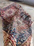 Red and navy Persian carpet showing natural patina and soft wool pile condition.