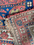 Underside view of an antique Persian rug woven with vegetable dyed wool.