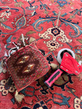 Collectible antique Persian carpet showcasing authentic vegetable dyes and century-old craftsmanship. Items placed on rug to show the difference in reds.