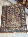 Antique Caucasian Shirvan rug with geometric tribal motifs on a warm wheat ground.