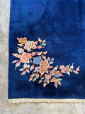 Corner view of Chinese rug made with vegetable-dyed wool, royal blue base, and florals.