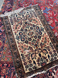 Authentic 100 year old Persian rug close-up photograph capturing the aged patina and hand-spun wool fibers.