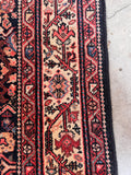 Hand knotted Persian runner 4x9 angled shot showcasing the thick weave, stout handle, and rich floral border.