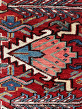 Graphic tribal motifs highlight the saturated vegetable dyed wool of this vintage Persian Heriz rug.