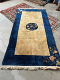 Antique Chinese wool rug with corner floral spray motifs and navy blue borders.