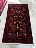 Vibrant vintage Persian rug 3x6, black ground with tribal peacock and animal motifs in berry red and tangerine