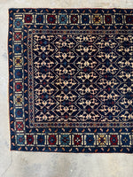 One end view of Antique Caucasian rug showcasing traditional motifs.