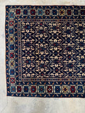 One end view of Antique Caucasian rug showcasing traditional motifs.