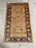 Vintage Turkish rug with warm camel field, all-over floral vine design and deep navy border, mid-20th century