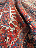 Rolled view showing border and side of antique Persian tribal wool rug
