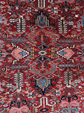 Geometric patterns and tribal elements across the center field of the rug.