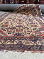 Vintage Persian rug with earthy background and purple highlights.