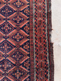 Traditional S-hook border rug detail photo showcasing protective symbol motifs along the outer woven frame.