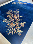 Antique 1930s Art Deco Chinese rug with royal blue ground and pastel floral motifs.