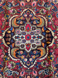 Vintage floral Persian rug with electric blue highlights and raspberry red field.