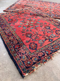 Small hand knotted wool rug in coral and navy blue featuring a floral chain design.