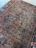 Tribal motifs and worn character on restored Heriz rug.