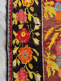 Detailed border of vintage Karabagh rug with colorful floral motifs and sturdy wool weave.