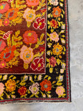 Corner detail of vintage Karabagh rug showing bright floral border and strong structure.