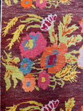 Close view of vintage Karabagh rug showing vibrant oversized blossoms on rich ground.