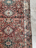 Handwoven Persian runner rug with mellow terracotta reds, walnut browns, and teal blue green accents.
