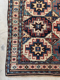 Corner view antique Caucasian Kazak runner rug with geometric star medallions and vegetable dyed wool.