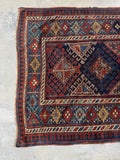 Vintage Kazak rug showing handmade character and slightly irregular edge.