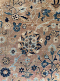 Antique Kerman rug closeup off botanical details on a neutral ground.