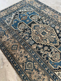 Antique Malayer rug featuring a central medallion and angular floral motifs.