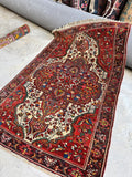 Antique Persian rug with fine curvilinear floral medallion in rich red and lavender.