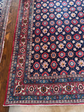 Corner view of vintage Persian rug with a Mina Khani floral lattice pattern in pink and navy blue wool.