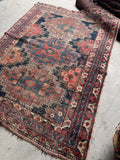 5x6 antique Persian tribal rug featuring geometric Afshar motifs in faded coral and indigo tones.
