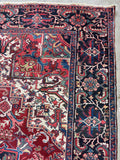 Antique Persian Heriz rug. Large red and navy hand knotted wool rug from Northwest Persia with striking central medallion and minimal wear.