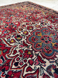 Close-up shot of central starburst medallion in red, navy blue, and ivory tones.