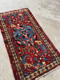 Vintage 1930s Persian rug with tribal design and jewel tones.