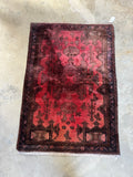 Full view of a 1970s vintage Persian rug with bold design and dark border.