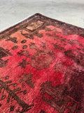 Detail of bird motifs woven throughout a deeply saturated vintage Persian rug.